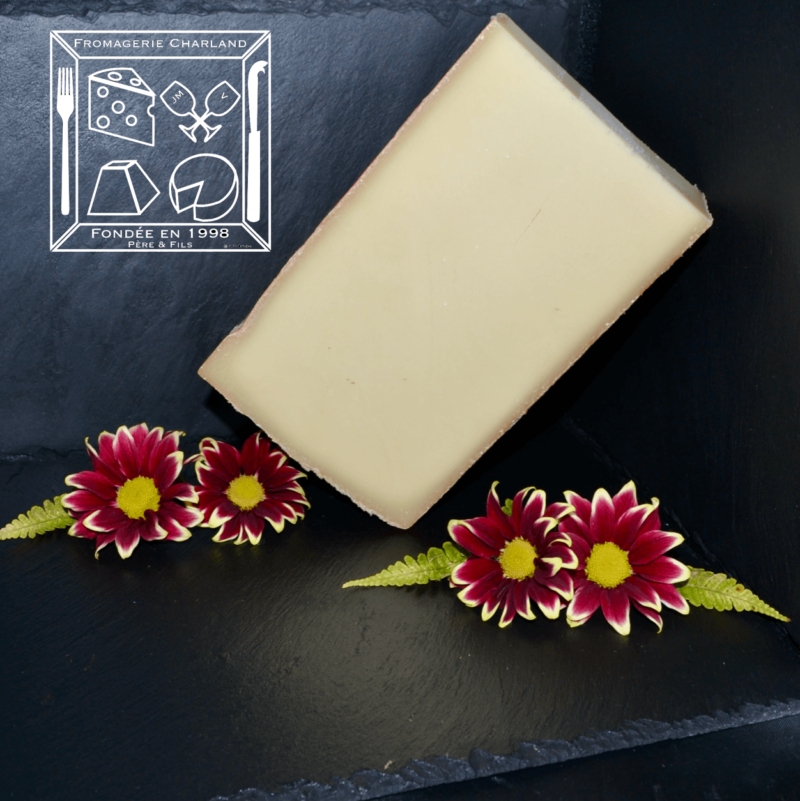 Morceau de meule des alpes en équilibre entre des fleures. Ce fromage à une texture très agréable puisque pour un fromage à pâte dure il n'est pas sec du tout mais très beurrant !